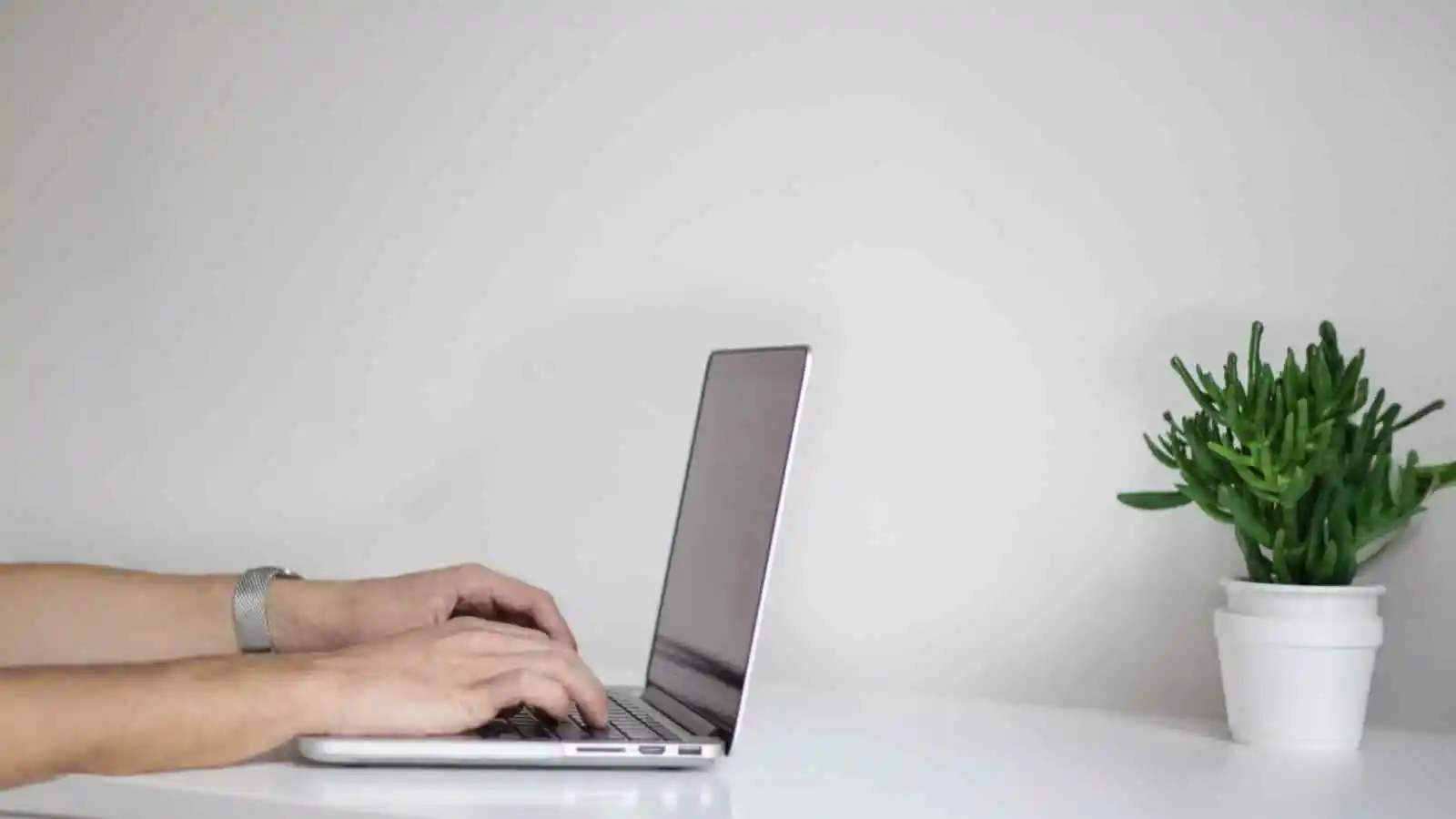 Persona trabajando de forma remota desde casa utilizando un computador portátil